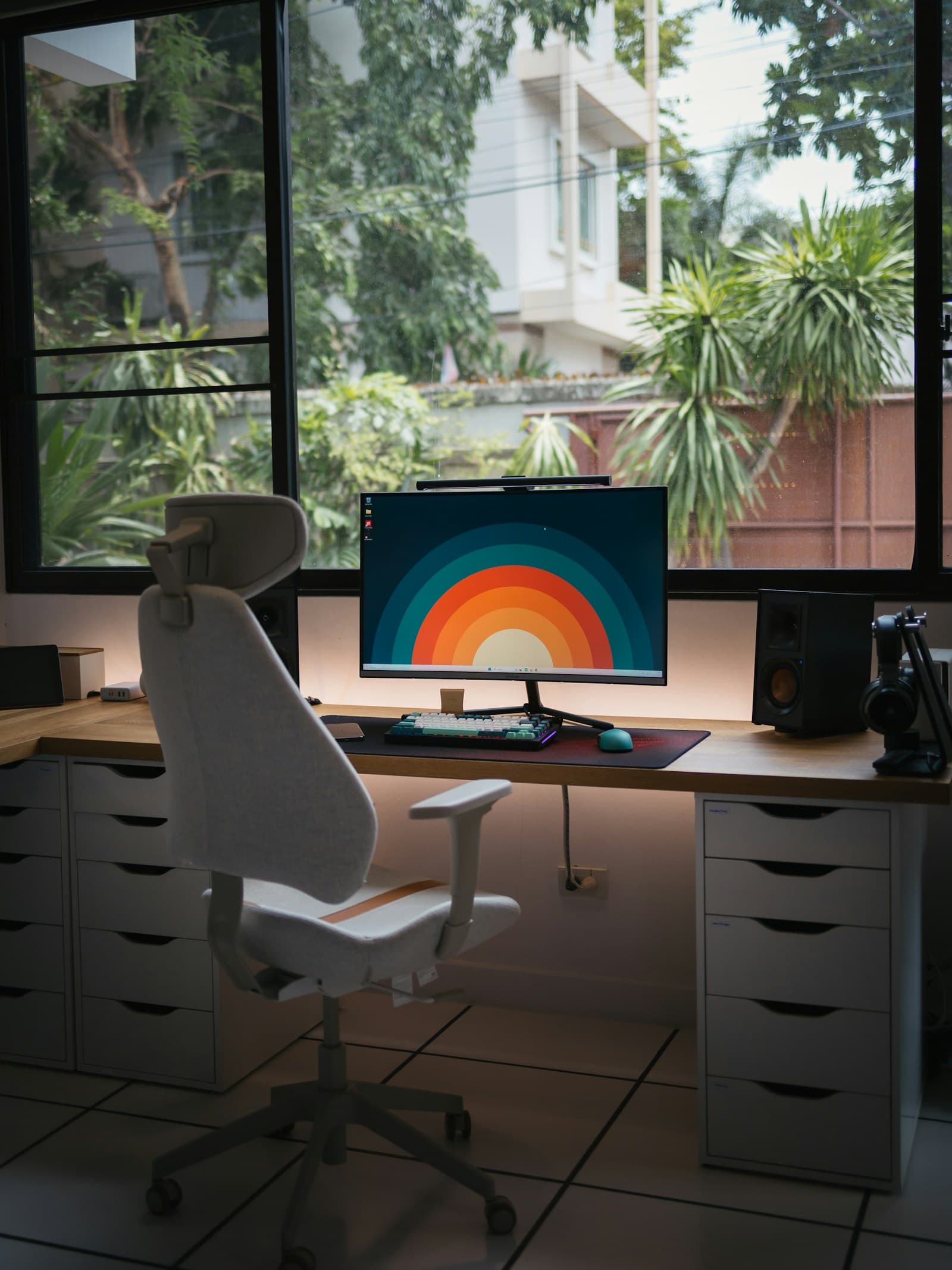 A computer workspace beside a large window